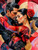 Romantic flamenco couple dancing closely in dramatic red attire with abstract geometric background and golden accents.