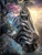 Close-up zebra portrait blended with a fantasy landscape of mountains, rivers, flowers, and a blooming tree.