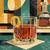 Elegant old fashioned whiskey cocktail with an orange twist beside a decanter in a retro mid-century modern geometric setting by 1000 No Kotoba.