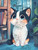 Adorable calico kitten with oversized blue eyes sitting inside a cozy home surrounded by books and houseplants.