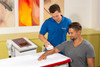 Practitioner using the emFieldPro medium dynamic applicator for contact-free High Energy Inductive Therapy of the forearm