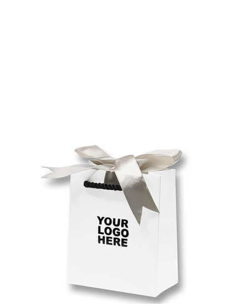 Matte white shopping bag with black twisted rope handles and champagne ribbon for gift wrapping