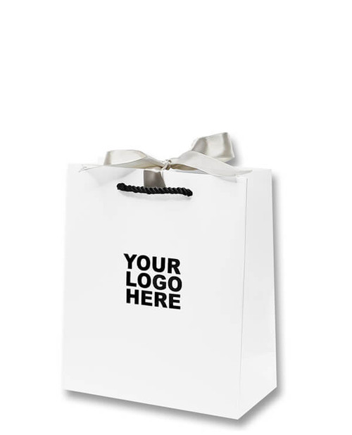 Matte white shopping bag with black twisted rope handles and champagne ribbon for gift wrapping