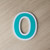 Outlined house number zero — green character with a white outline running around the outside and through the middle, 3D printed ASA