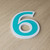 Outlined house number six, green character on a white base, shown at an angle — the outline follows the character shape and circles the counter, 3D printed ASA