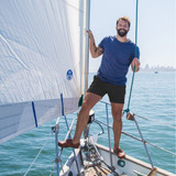 Man on boat wearing Chubbies Men's Midnight Adventures 6" Stretch Shorts and blue shirt