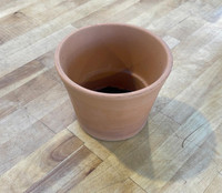 Deroma Terra Cotta - Half Cono 5.5in, empty terracotta plant pot on wooden floor.