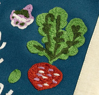 1canoe2 Embroidered Canvas Banner, embroidered image of a strawberry with green leaves and a small purple flower, on a blue fabric background.