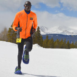 Runner wearing Luna foam snowshoes with crampons on snowy trail Runner wearing Luna foam snowshoes with crampons on snowy trail