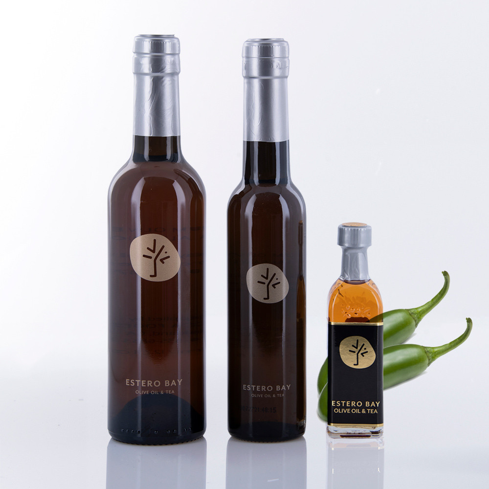 Three different size bottles of Estero Bay Olive Oil & Tea Jalapeño White Balsamic Vinegar.