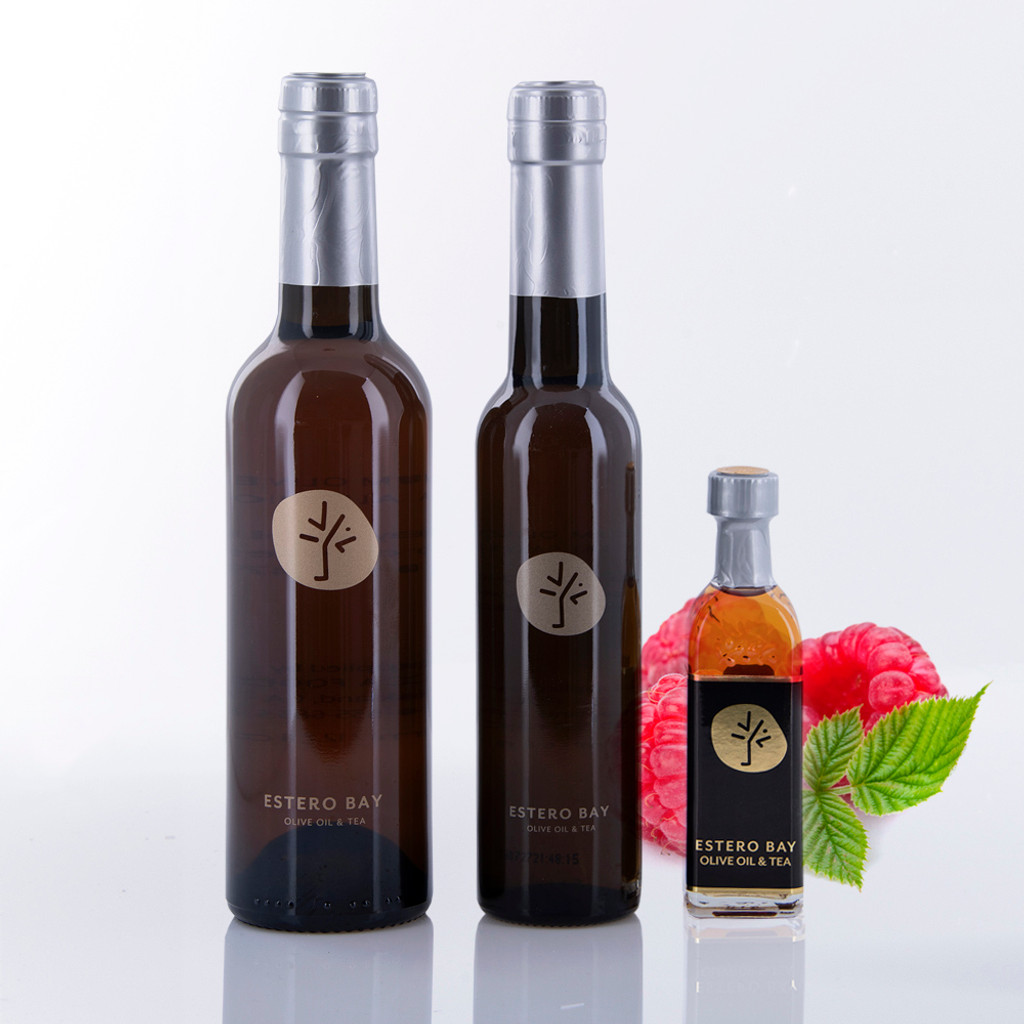 Three different size bottles of Estero Bay Olive Oil & Tea Wild Raspberry White Balsamic Vinegar.