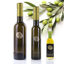 Three different size bottles of Estero Bay Olive Oil & Tea Greek Koroneiki in front of an olive branch