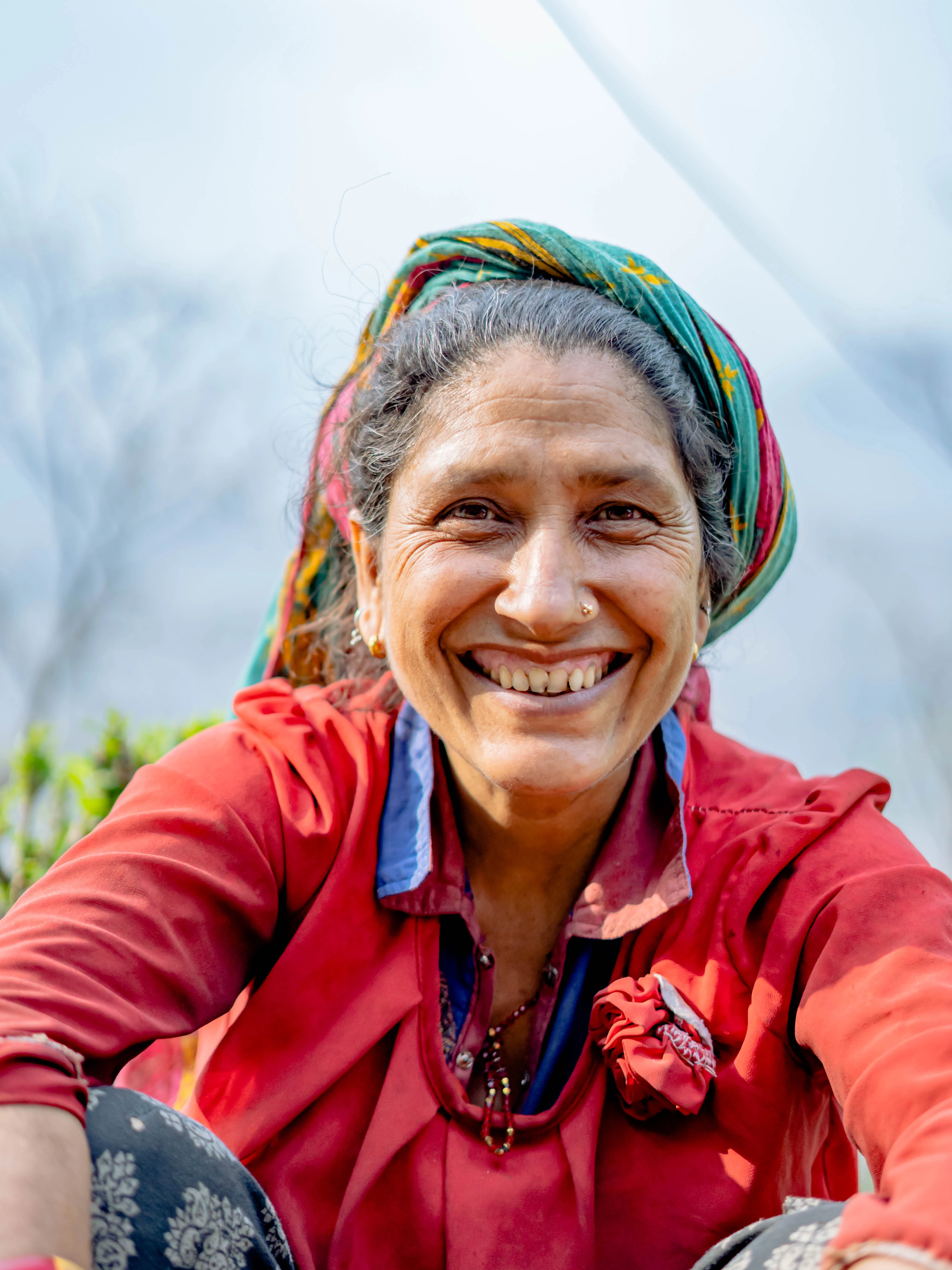 A tea grower smiling in the gardens of Nepal