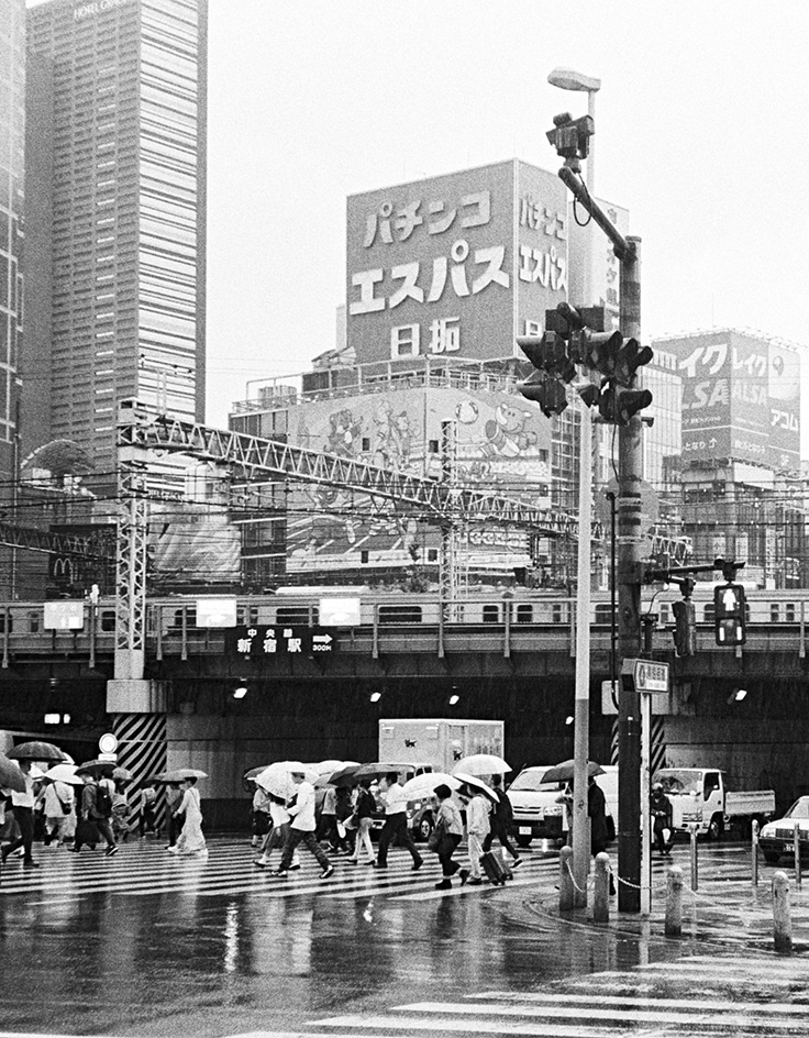 Old black and white photo of people crossing the street.