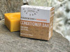One Earth Body Care Conditioner Bar for Oily Hair, Frankincense-Tangerine aroma. Naked square conditioner bar next to compostable box package.