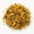 Loose dried arnica flowers on a warm-white background.