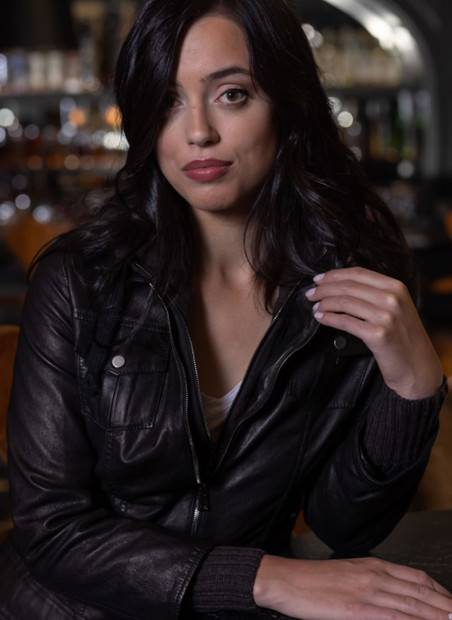 Zipped on model view of black Colorado Collection Lamb hooded jacket. 2 snap chest pockets, zip closure, knit cuffs, hood and waist band.