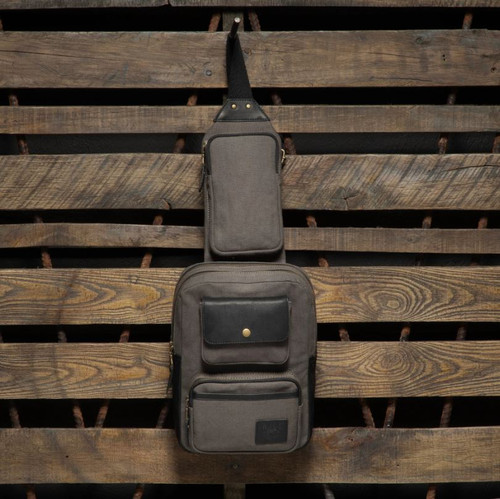 Embrace your adventures with the Commuter Collection Canvas and Leather Sling Pack, a versatile and stylish companion for your everyday journeys. Whether you're navigating bustling streets, exploring hidden corners, or simply enjoying the city's vibrant energy, this sleek and functional sling pack will keep your essentials secure and organized.

Meticulously crafted with a harmonious blend of durable canvas and soft leather, this sling pack embodies the perfect fusion of practicality and timeless design. You'll never have to sacrifice style for functionality as it boasts a spacious main compartment for your larger items, multiple pockets for organized storage to keep your tech secure, and a dedicated smartphone sleeve for easy access. Stay organized and prepared for whatever your day may bring, all while navigating the city with ease.

• Full-grain vegetable-tanned leather
• 14 oz cotton canvas
• Zinc-alloy hardware
• Ample storage space
• Several interior organizational pockets
• Interior tablet sleeve (fits up to a 14” tablet)
• Exterior easy access zippered smart phone pocket
• Chambray Lining
• Adjustable canvas cross-body strap
• Leather and security metal mesh luggage tag
• Dual Zippered Compartments
• Dimensions: 11.5” x 8.5” x 4”
• Weight: Approx. 2 lbs
• Imported