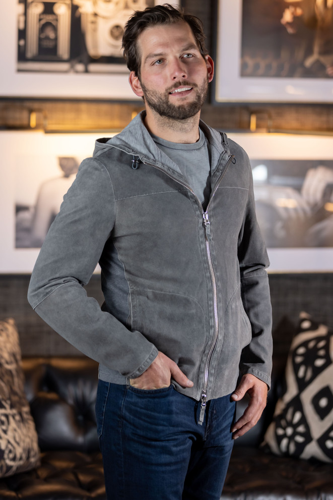 A man wears a Colorado Collection by Avalon hooded lambskin leather jacket. The jacket features a bonded lining and zip closure. This leather coat is made in Italy. Front view.