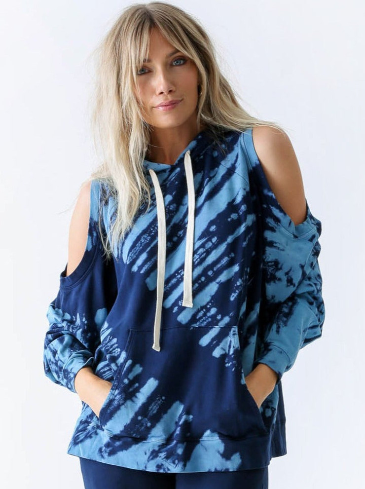 Front view of Electric & Rose cotton blend hoodie. This hoodie has drawn strings to adjust the hood, as well as exposed shoulder style with different shades of blue tie dye design.
