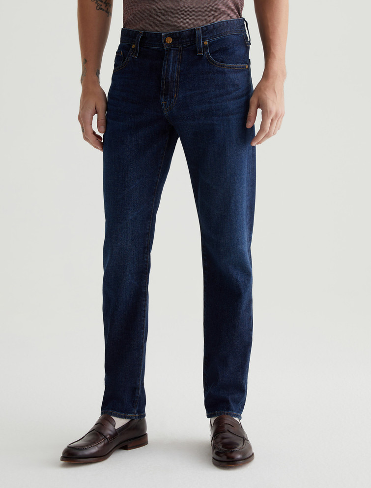 The Tellis modern slim jean for men comes in a dark blue wash with a 5-year AG-ed™ vintage fade
Whiskering and crease marks create a naturally worn-in appearance
Featuring a fitted upper block and tapered leg opening, this five-pocket men's jeans are crafted from 10 oz. Daytripper Stretch Denim for premium comfort
Contrast stitching completes the look 
Model is wearing size 31.
• Front Rise: 10"
• Knee Opening: 15 7/8"
• Bottom Opening: 13 3/4"
• Inseam: 33" 

Daytripper Stretch Denim, 10 Oz. 72% Cotton, 26% Lyocell, 2% Polyurethane