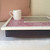 rosy pink lap tray with cream frame and tablet on top of it