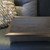 dark wood lap tray with silver frame and grey cushion on a sofa