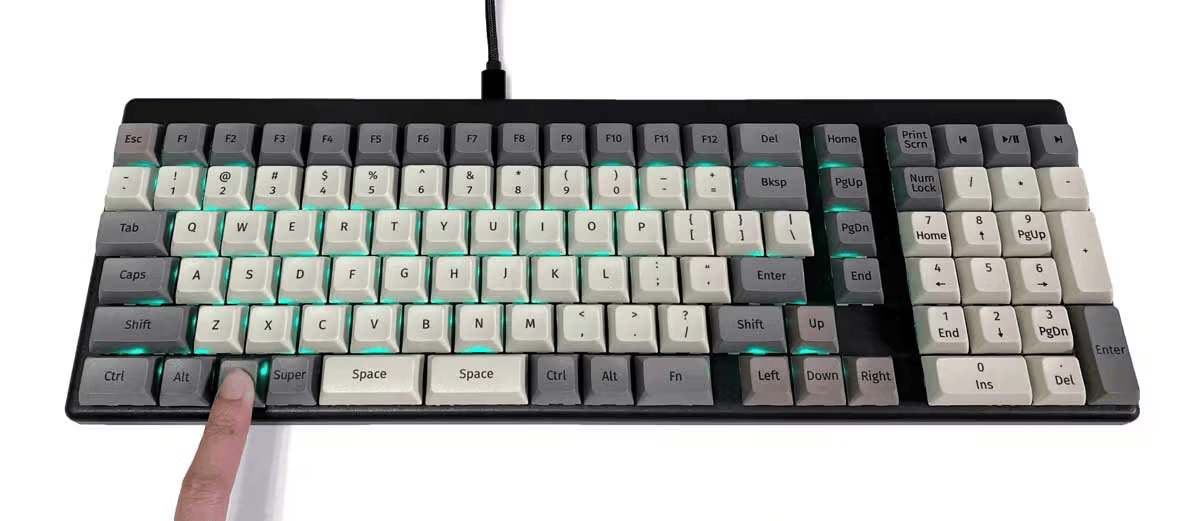 Launch Heavy Keyboard with green backlights. A finger holds down the Fn key.