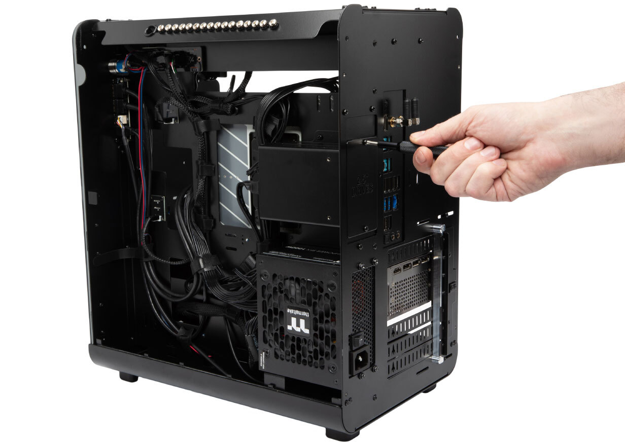 Thelio showing internals with a hand holding a screw driver unscrewing a screw