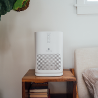 White Air Purifier on a table top in a bedroom