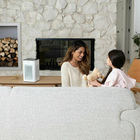 White Air Purifier on a table top in the living with a mother and young daughter playing together.