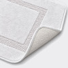 Details image of a white microfiber bath rug showing the latex backing.