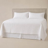 White Palmetto coverlet and pillow shams on an upholstered bed.