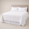 A white Palmetto queen size coverlet set on a queen size bed.