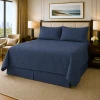 A hotel room setting showing a nautical blue king quilted coverlet set.