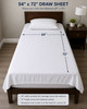 White 54x72 draw sheet with a diagram on a bed