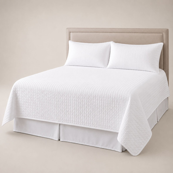 A white Palmetto queen size coverlet set on a queen size bed.