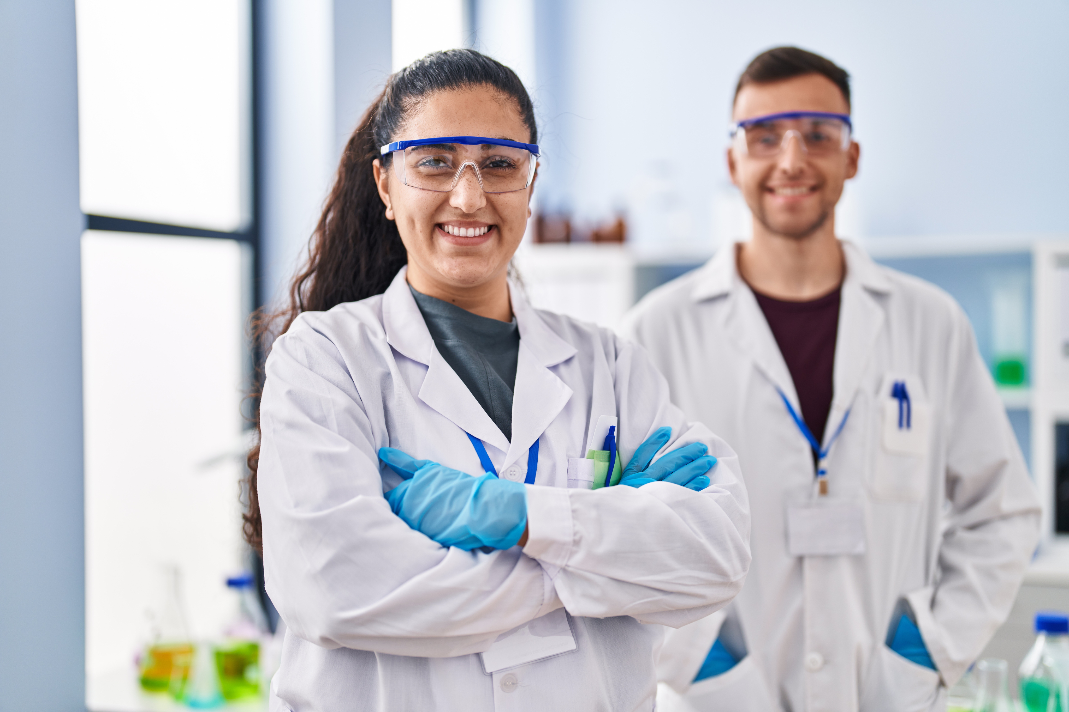 Lab technicians working in a lab with safety equipment