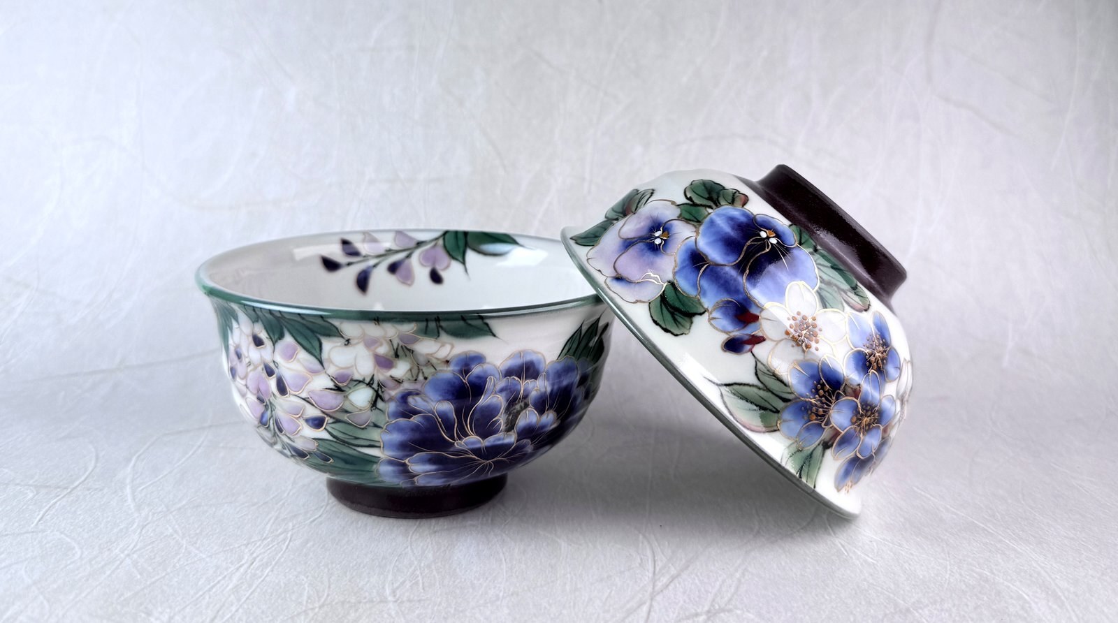 A pair of hand-painted Kiyomizu-yaki bowls with blue and purple floral motifs and gold outlines