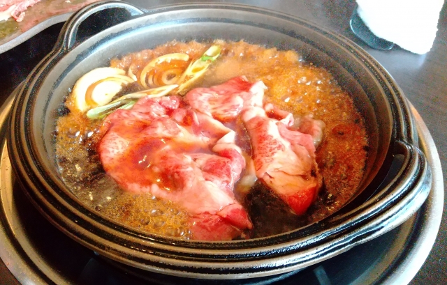 Thin slices of beef and leek in a bubbling pot.