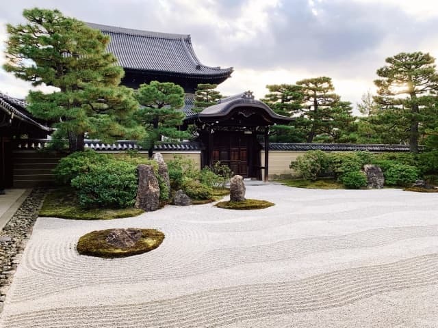 Kyoto karesansui zen garden with raked gravel and moss-covered stones