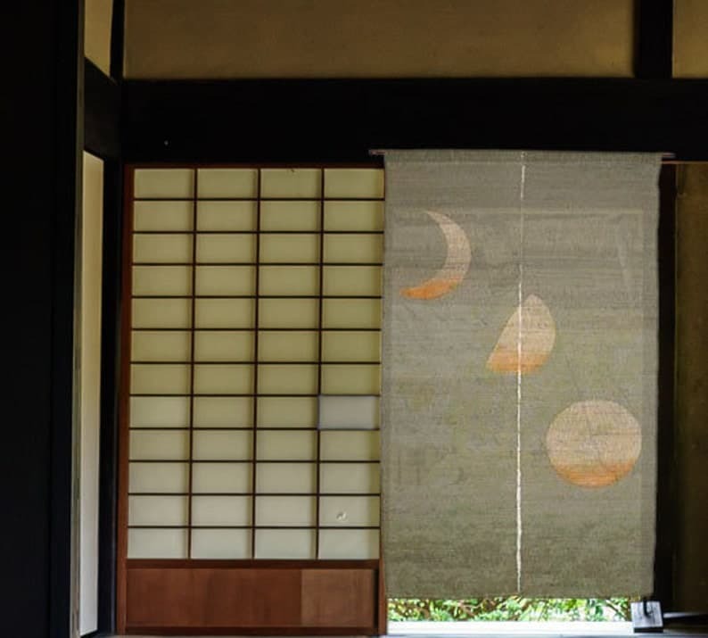 Japanese linen noren with moon motif hanging beside a shoji screen