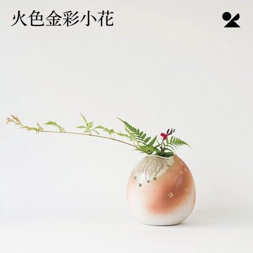 A round Shigaraki-ware vase where a pale glass-like glaze flows down into a warm scarlet base, with small gold accents