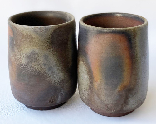 A pair of Bizen sangiri yunomi cups — cool gray-blue and orange tones from the kiln