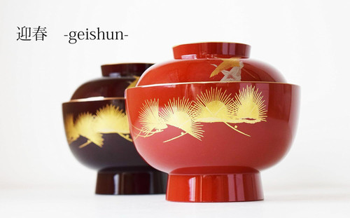 Two Yamanaka lacquered soup bowls in red and black with gold crane maki-e, set for a warm meal