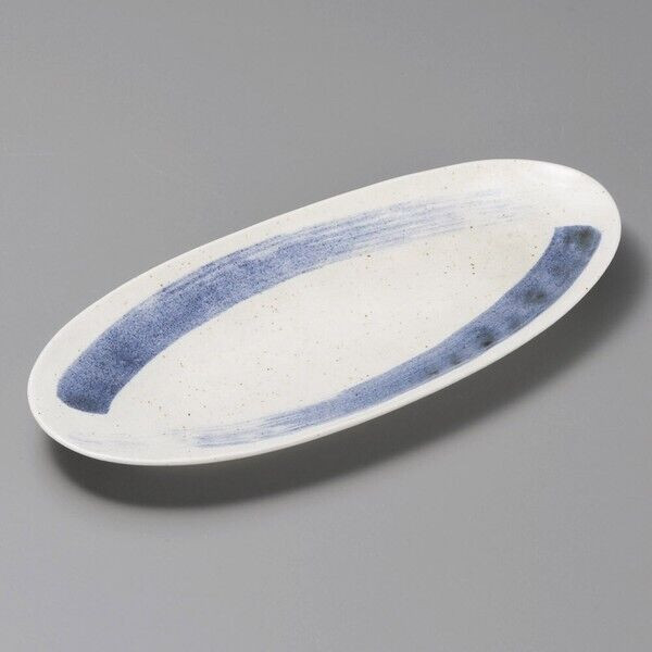 A long, shallow Mino ware oval plate in speckled off-white with a single broad indigo brushstroke running along its length