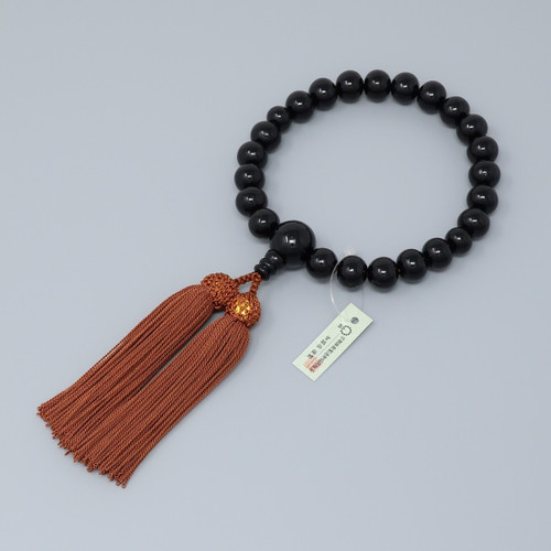 A Kyoto ebony juzu — a single loop of dark wooden prayer beads with a brown tassel
