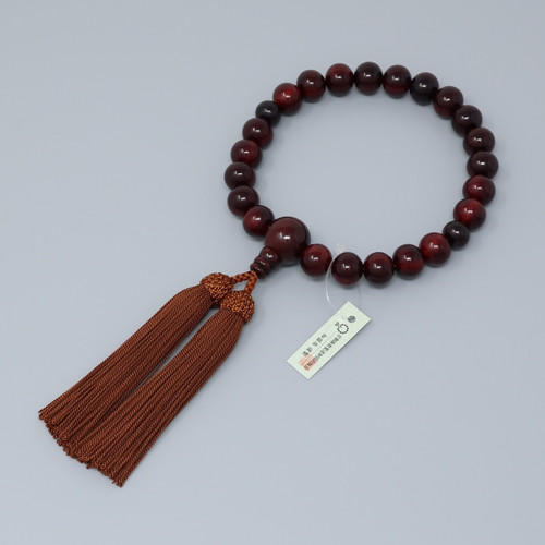 A Kyoto rosewood juzu — a single loop of warm brown wooden beads with a tassel