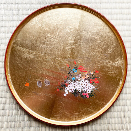 A round Yamanaka lacquered tray finished in gold leaf, photographed on tatami
