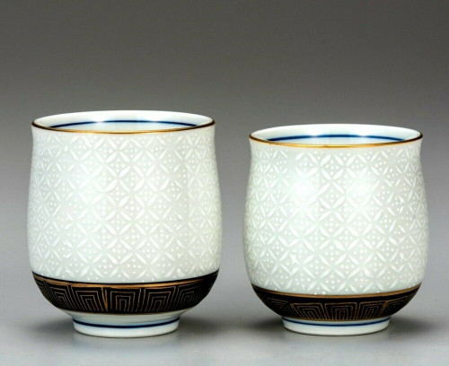 A pair of Kutani porcelain yunomi teacups in the white shippo seven-treasures pattern